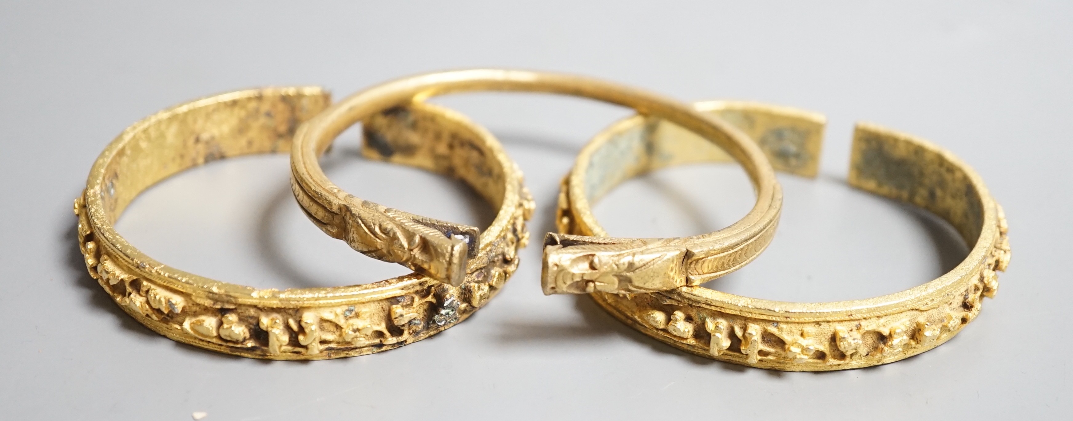 Three Chinese gilt bronze bangles, 19th/early 20th century